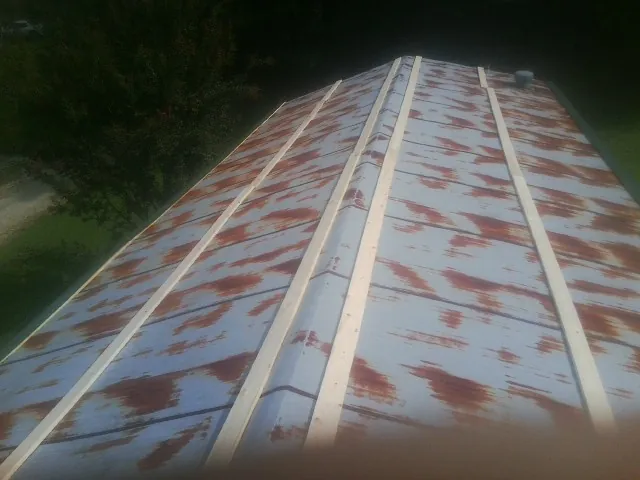 Rusted metal roof panels with new wood purlins before replacement — Storm Damage Roof Repair in Joint Base Mdl by Roofing Brothers