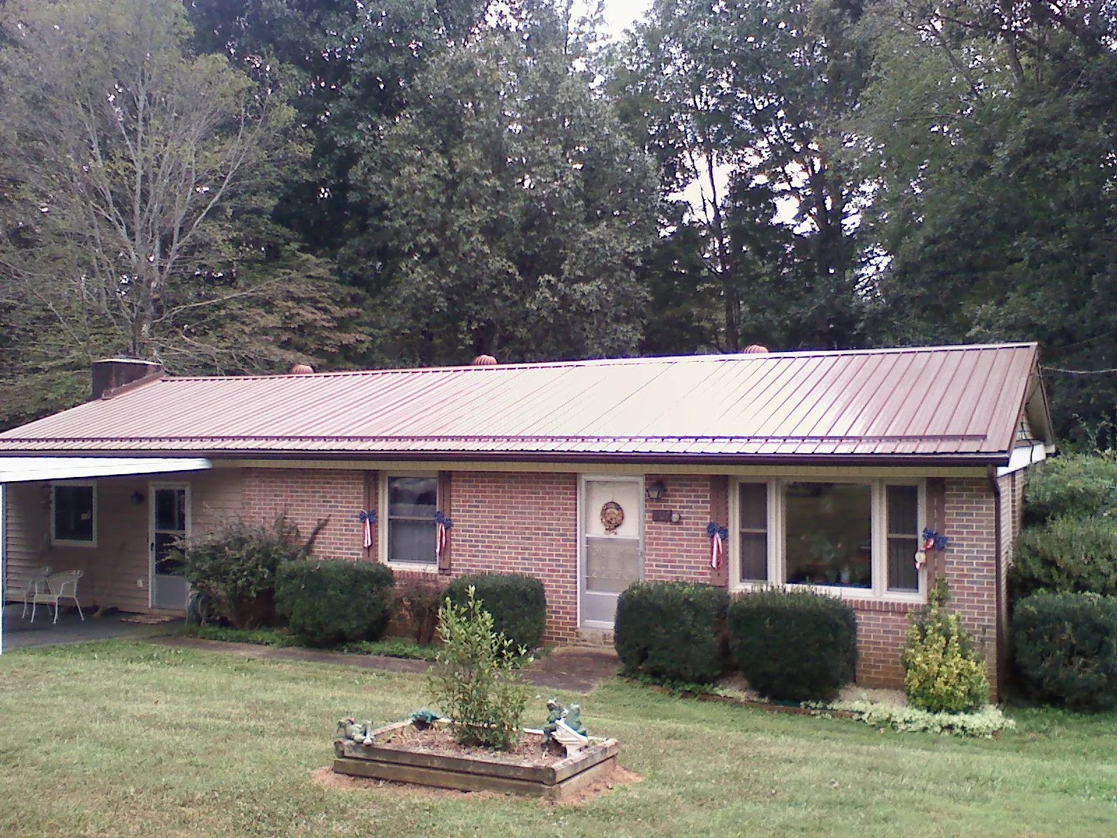 Bronze metal roof on a brick ranch home with a carport in Joint Base Mdl