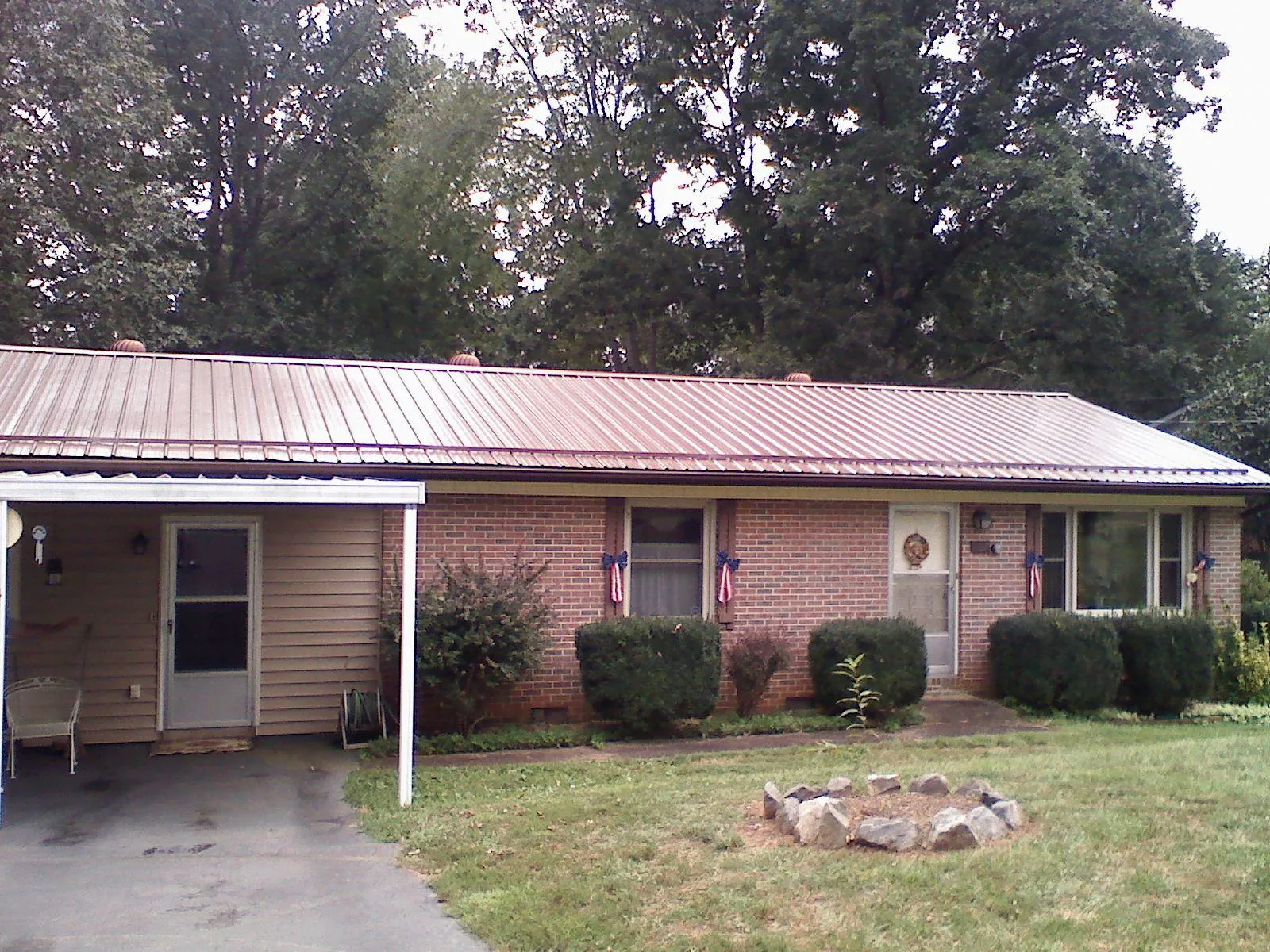 Bronze metal roof and carport on a brick ranch home — Roof Repair work by our crew in Joint Base Mdl